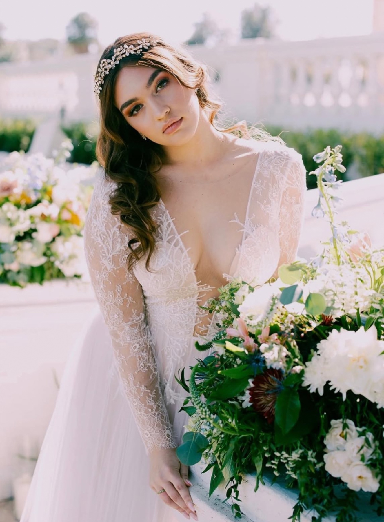 Bride in lace long-sleeve gown holding an airy garden bouquet