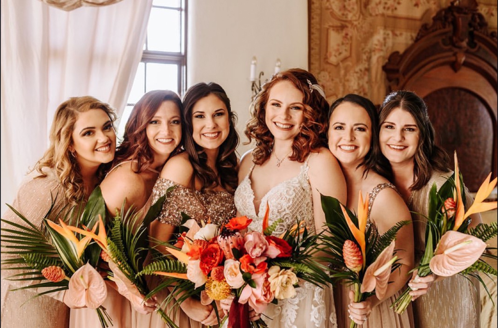 Bridal party of six with tropical bouquets, bride in the center