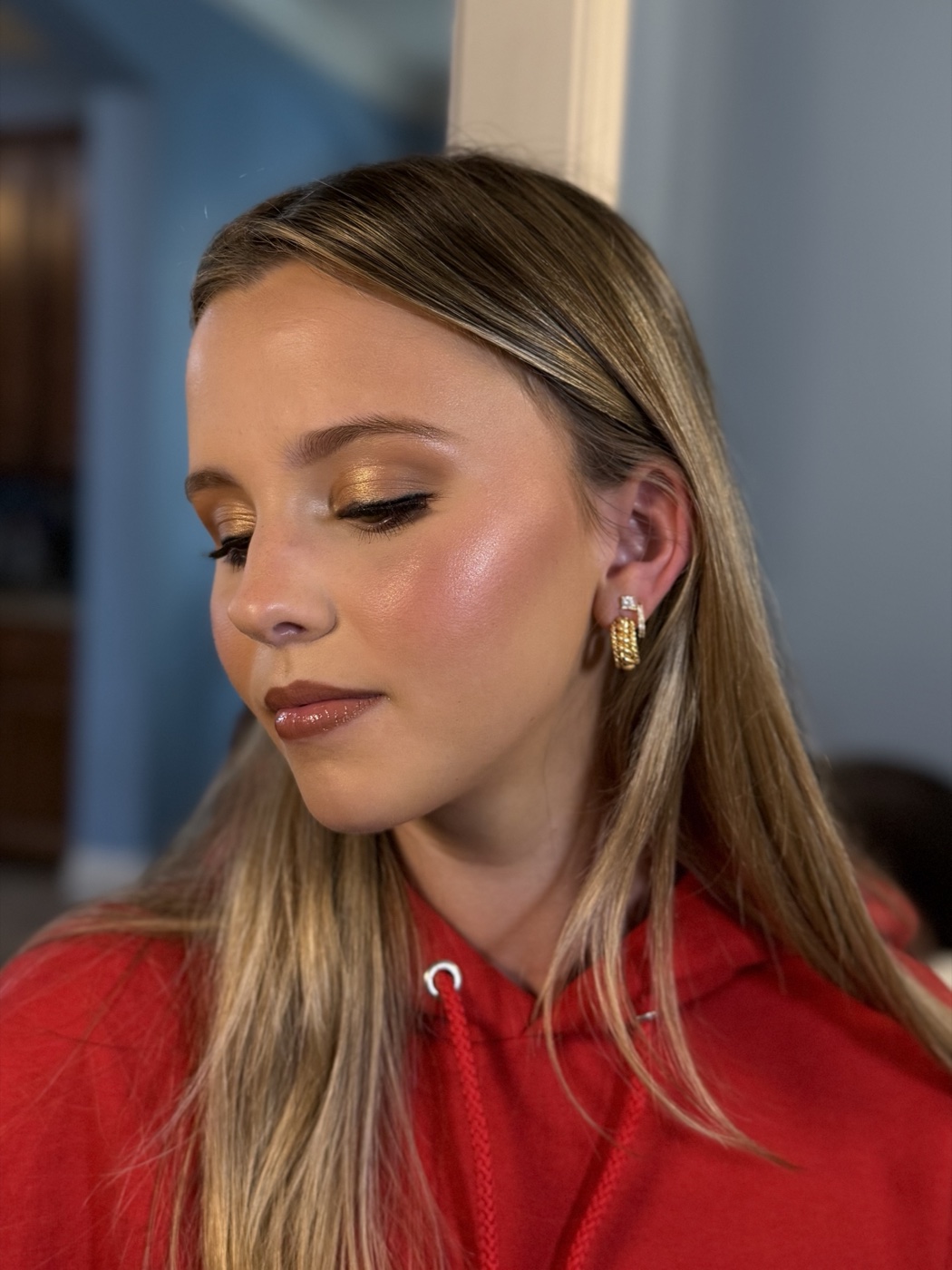 Close-up of golden-bronze eye makeup with glossy brown lip