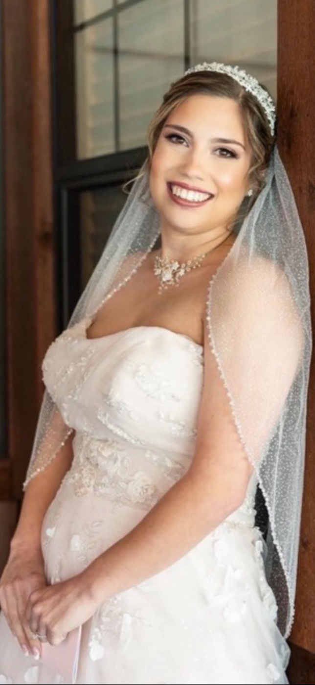 Bride in lace gown with cathedral veil and soft waves